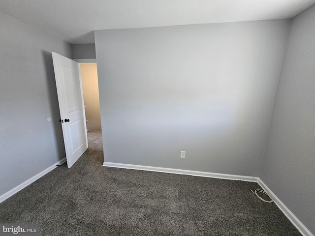 unfurnished room with dark carpet