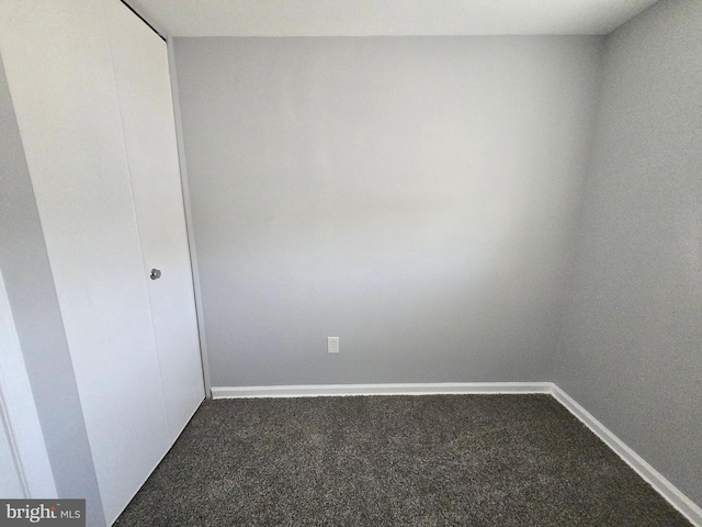 empty room with dark colored carpet