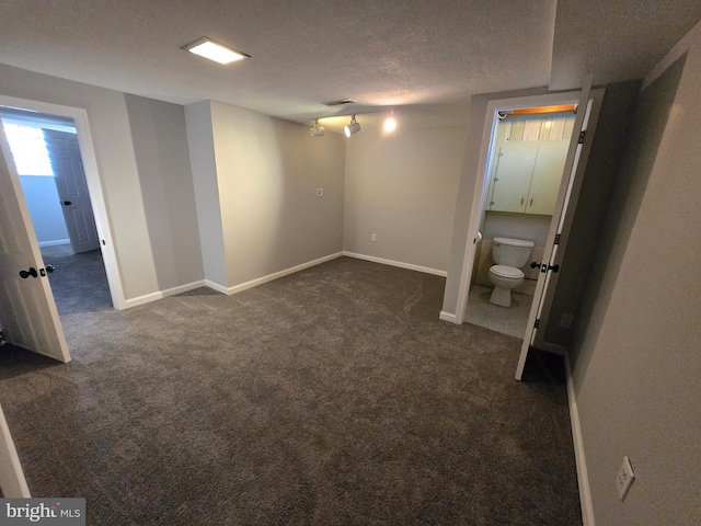 interior space with dark carpet and a textured ceiling