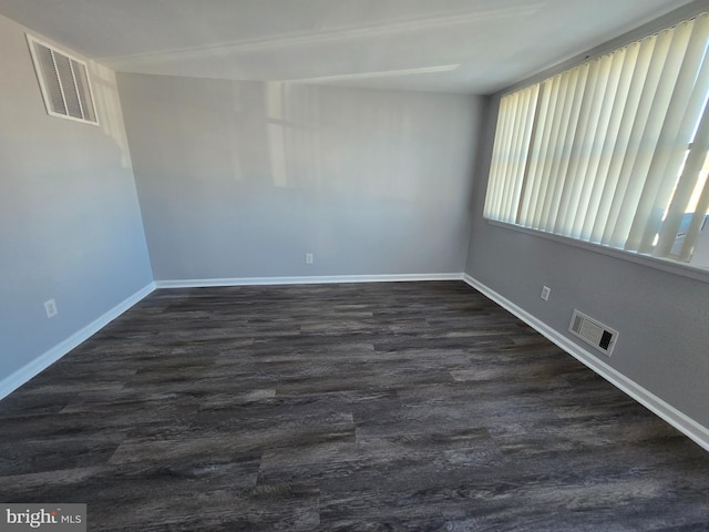 unfurnished room with dark wood-type flooring