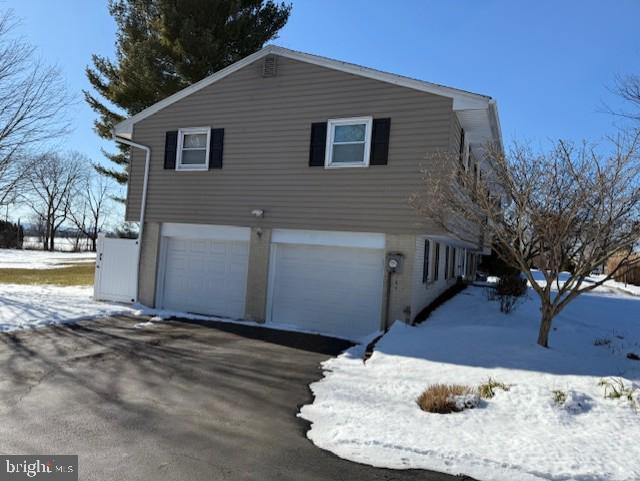 view of snow covered exterior featuring a garage