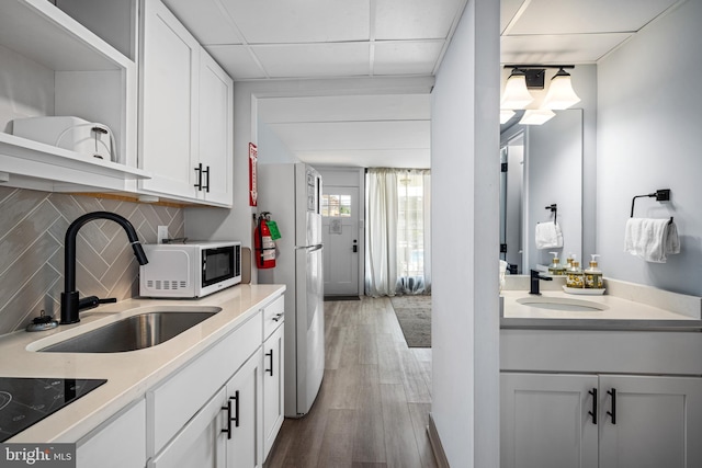 kitchen featuring white cabinetry, sink, and black electric stovetop