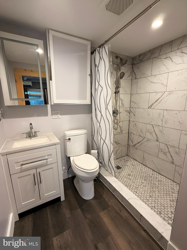 bathroom with wood-type flooring, toilet, a shower with shower curtain, and vanity