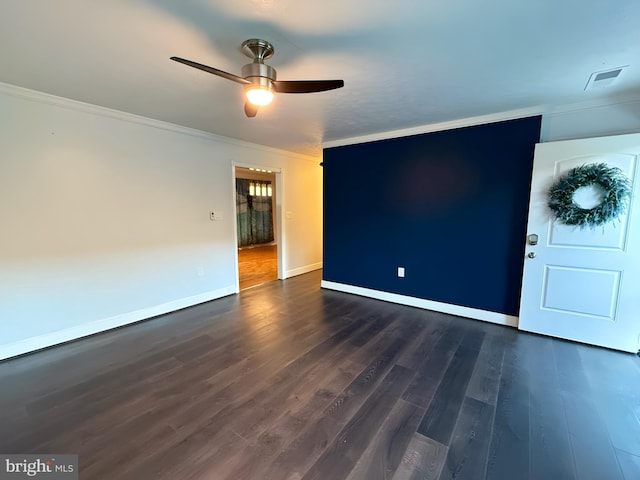 spare room with crown molding, ceiling fan, and dark wood-type flooring