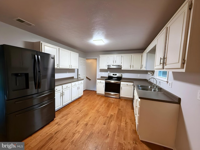 kitchen featuring sink, stainless steel electric range, black refrigerator with ice dispenser, and white cabinets