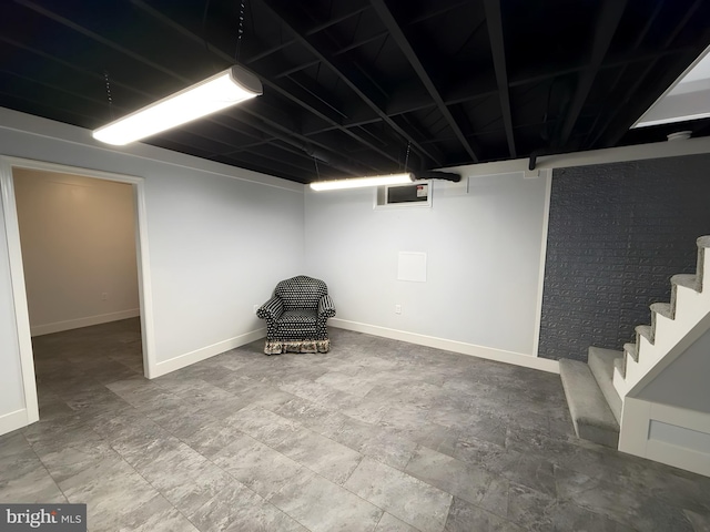 unfurnished room featuring brick wall