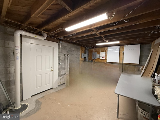 basement with electric panel and refrigerator