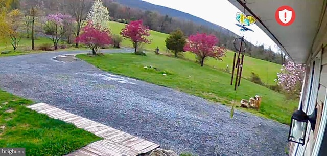 surrounding community featuring a mountain view and a lawn