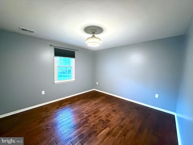 unfurnished room with hardwood / wood-style flooring