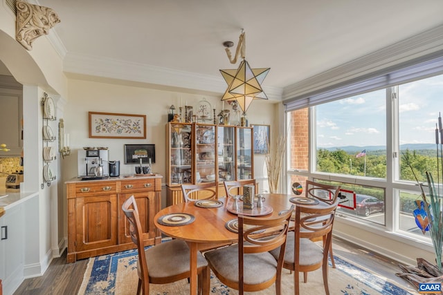 dining area featuring ornamental molding and dark hardwood / wood-style floors