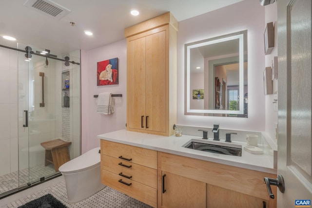 bathroom with vanity, a shower with door, and toilet