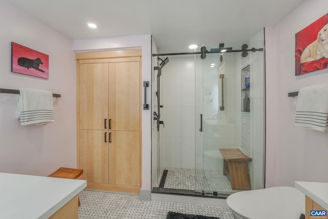 bathroom featuring vanity, a shower with shower door, and toilet