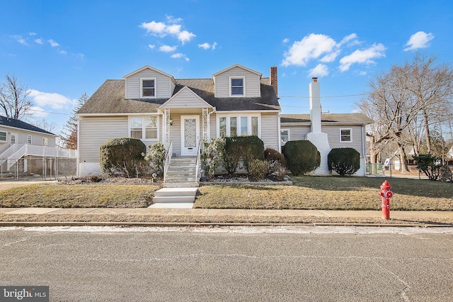 new england style home featuring a front yard