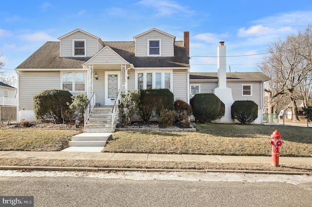 cape cod-style house with a front lawn