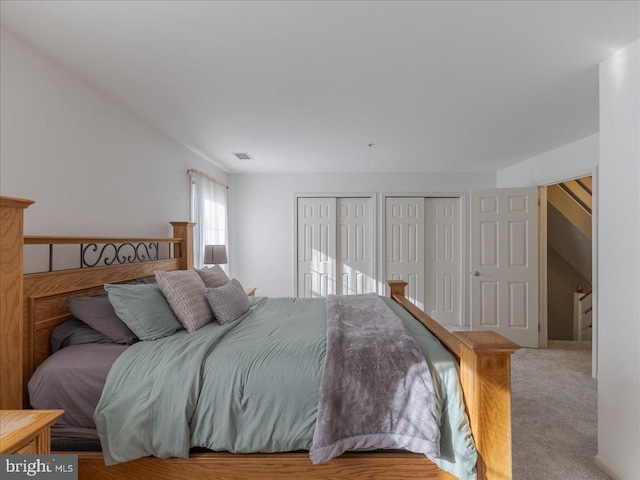 bedroom featuring multiple closets and carpet flooring