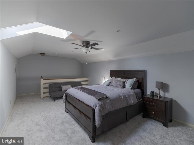 carpeted bedroom featuring vaulted ceiling with skylight and ceiling fan