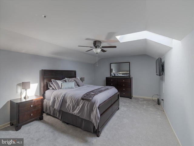 carpeted bedroom with lofted ceiling with skylight and ceiling fan