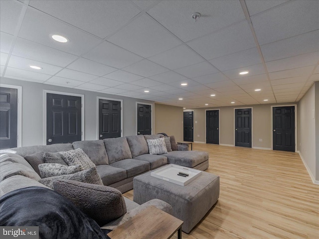 living room featuring a drop ceiling and light wood-type flooring