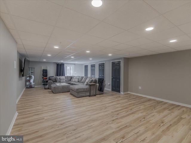 unfurnished living room featuring a drop ceiling and light hardwood / wood-style floors