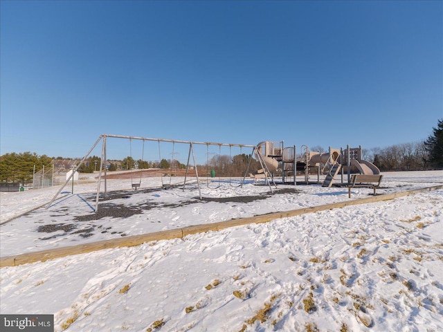 yard layered in snow featuring a playground