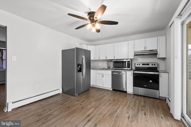 kitchen featuring sink, stainless steel appliances, white cabinets, and baseboard heating