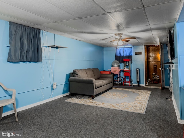 living room featuring a drop ceiling and ceiling fan