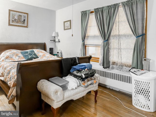 bedroom featuring radiator heating unit and wood-type flooring