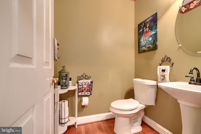 bathroom with toilet and hardwood / wood-style floors