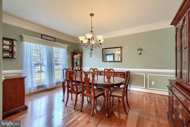 dining room featuring an inviting chandelier, crown molding, and light wood-type flooring