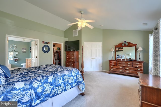 bedroom featuring ensuite bathroom, lofted ceiling, carpet, ceiling fan, and a closet