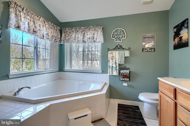 bathroom featuring lofted ceiling, toilet, vanity, a relaxing tiled tub, and tile patterned flooring