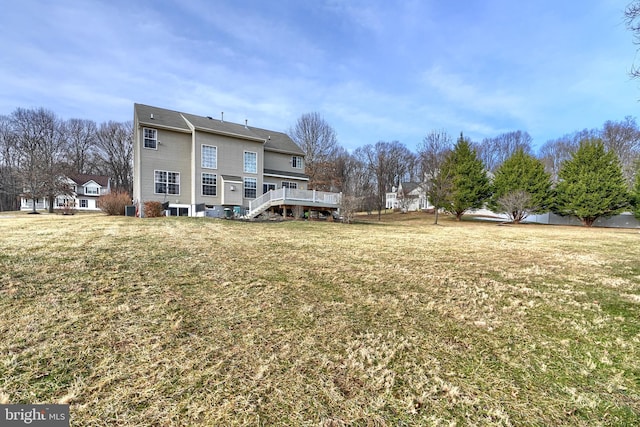 rear view of house featuring a deck and a lawn