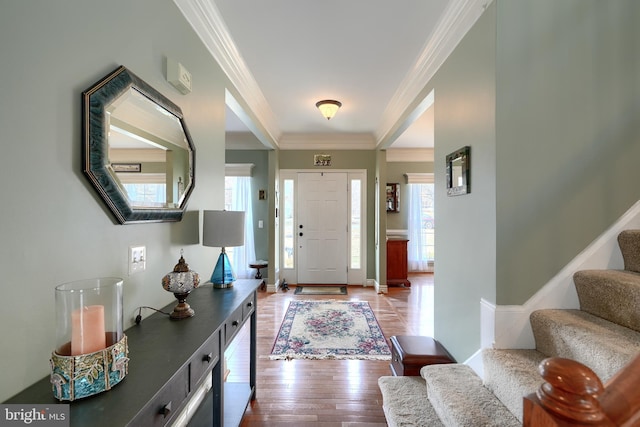 foyer with hardwood / wood-style flooring and crown molding