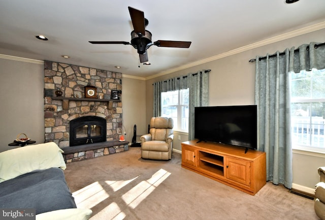 living room with crown molding, a wealth of natural light, a fireplace, and light colored carpet