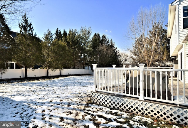 yard covered in snow featuring a deck