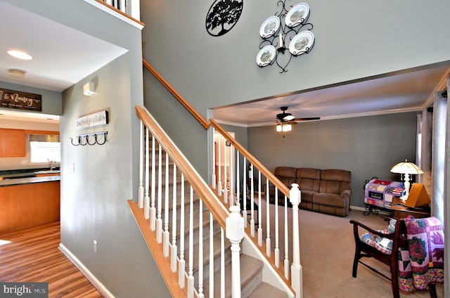 staircase with crown molding and ceiling fan