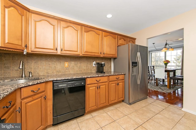 kitchen with sink, dishwasher, stainless steel fridge with ice dispenser, and dark stone countertops