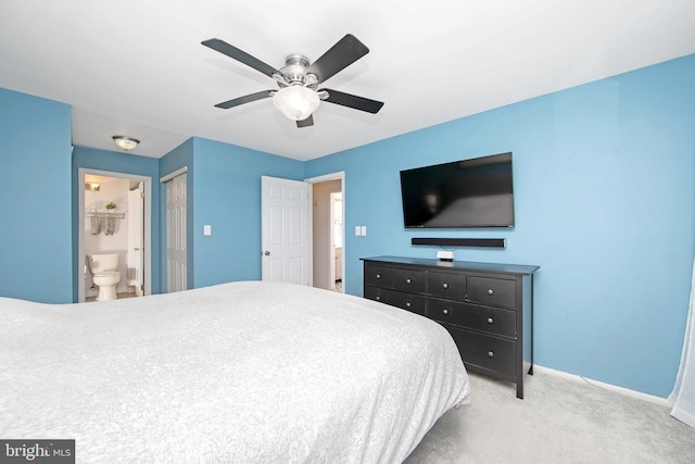 bedroom with ceiling fan, connected bathroom, and carpet flooring