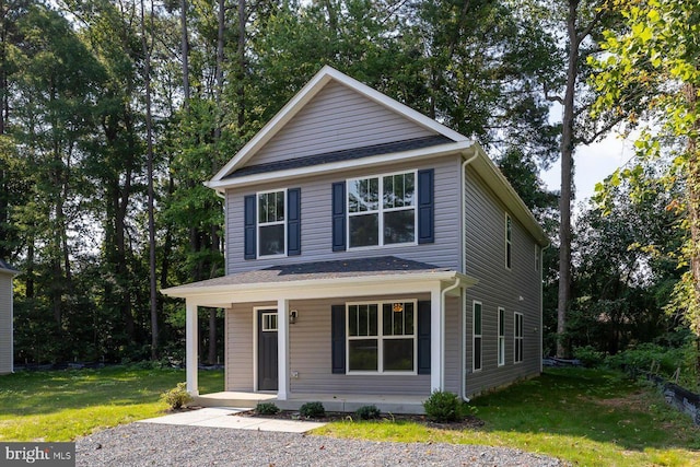 front facade featuring covered porch and a front yard