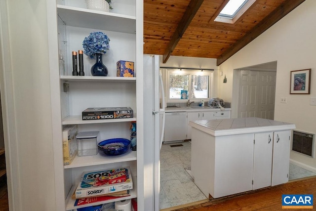 kitchen with lofted ceiling with skylight, wood ceiling, tile counters, dishwasher, and white cabinets