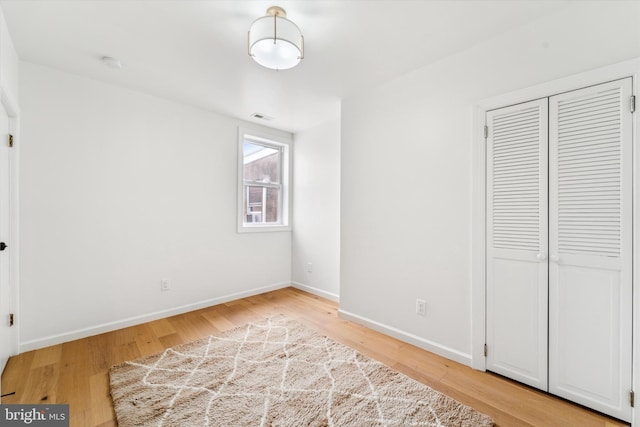 unfurnished bedroom featuring light hardwood / wood-style floors and a closet