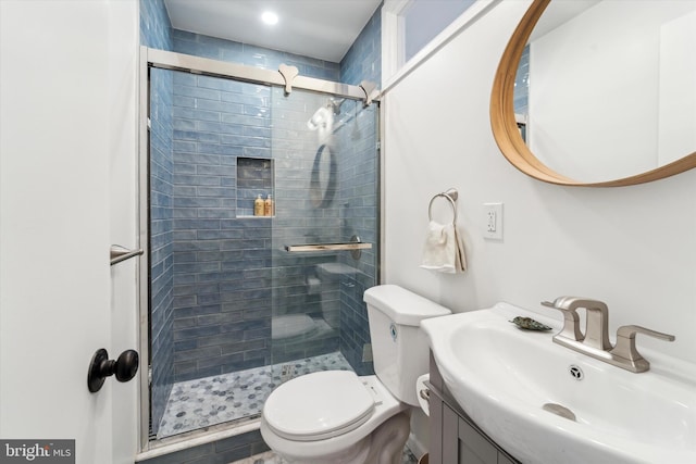 bathroom with vanity, toilet, and a shower with shower door