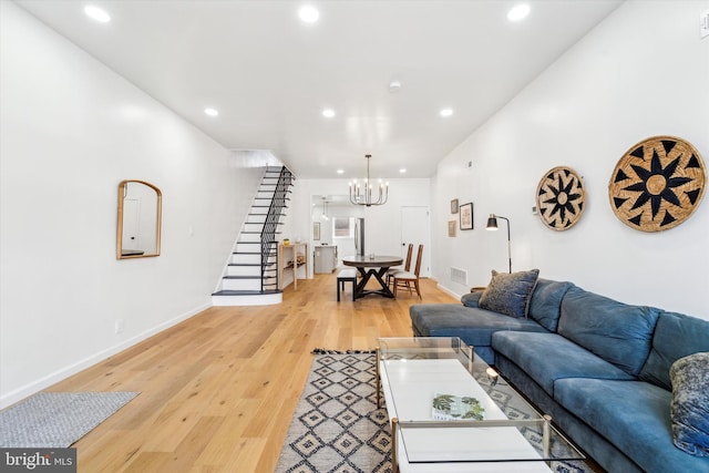 living room with a chandelier and light hardwood / wood-style flooring