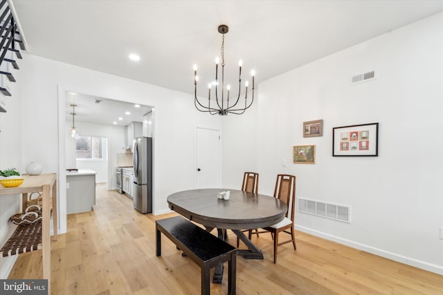 dining space with a chandelier and light hardwood / wood-style flooring