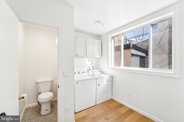 washroom with washer and dryer and light wood-type flooring