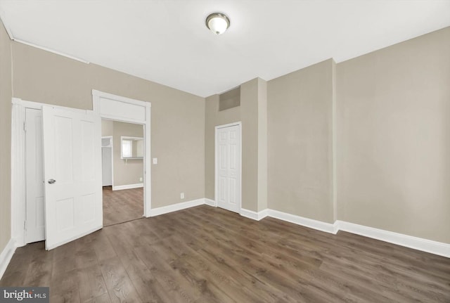 unfurnished bedroom with dark hardwood / wood-style floors and a closet