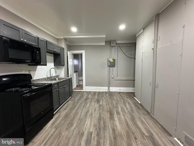 kitchen with sink, gray cabinetry, tasteful backsplash, black appliances, and light wood-type flooring