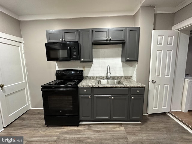 kitchen with sink, gray cabinetry, hardwood / wood-style floors, black appliances, and decorative backsplash