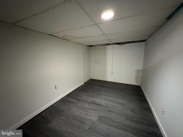 basement with dark wood-type flooring and a drop ceiling