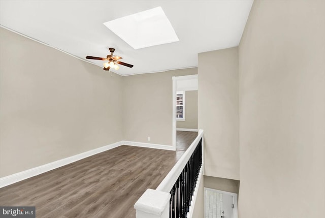 interior space featuring hardwood / wood-style floors, ceiling fan, and a skylight